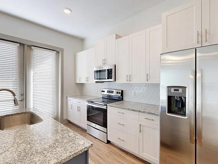 Apartment Kitchen with Granite counter tops and Wood Style Flooring.