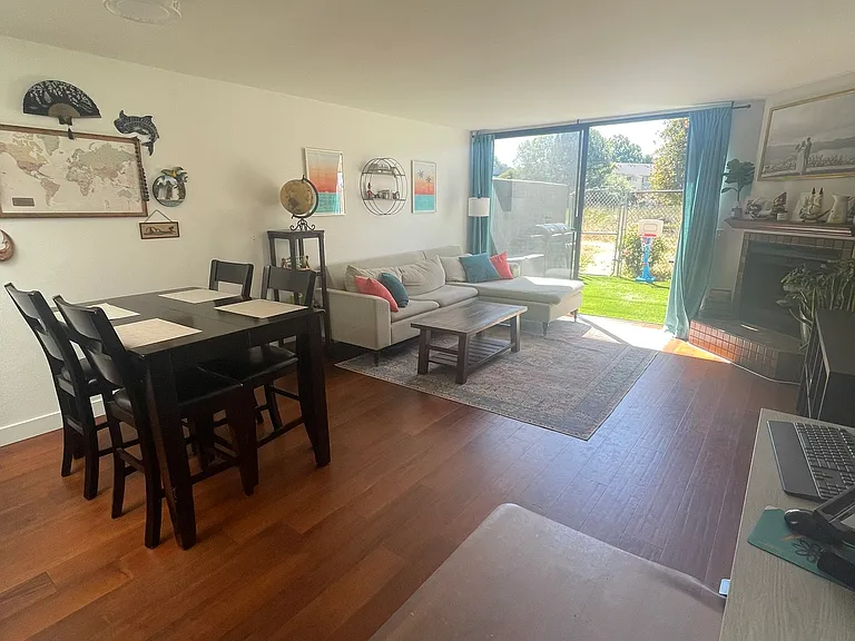 Open floor dining/living room with sliding door to gated backyard