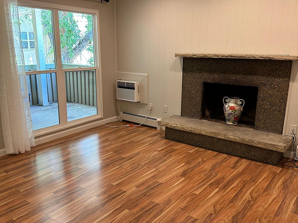 LIVING AREA WITH DECORATIVE FIREPLACE AND LARGE WINDOWS TO PORCH