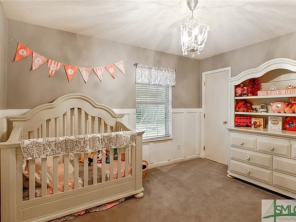 SECOND BEDROOM WITH WOODEN WAINSCOTING ON ALL WALLS.