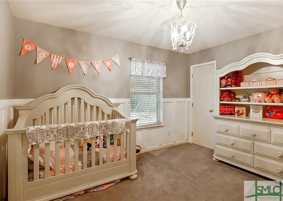 SECOND BEDROOM WITH WOODEN WAINSCOTING ON ALL WALLS.