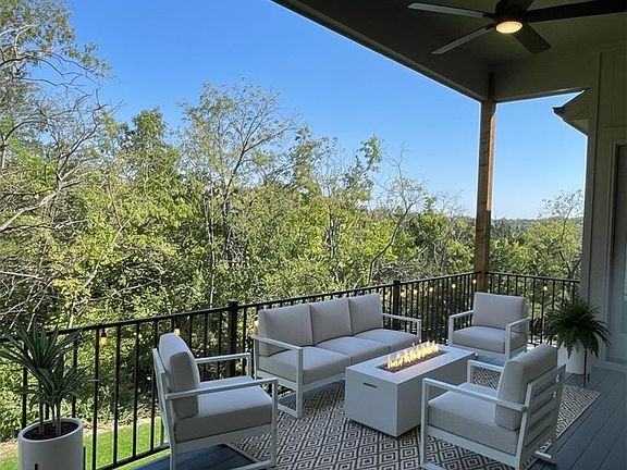 An elevated covered deck overlooks a scenic wooded backdrop.
