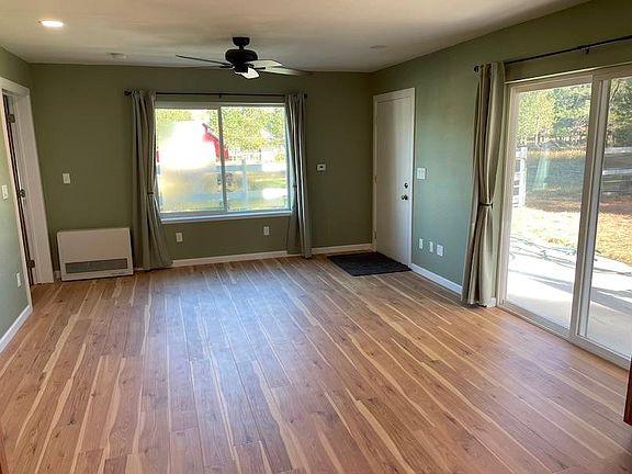 Apartment living room, entry door on far right and sliding glass door near right