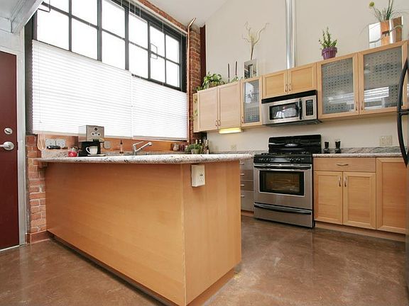 The Chef's Kitchen Has a Copper Backsplash, Stainless Steel Appliances, Granite Slab Countertop, Birch Cabinets With Glass and Stainless Steel Accents