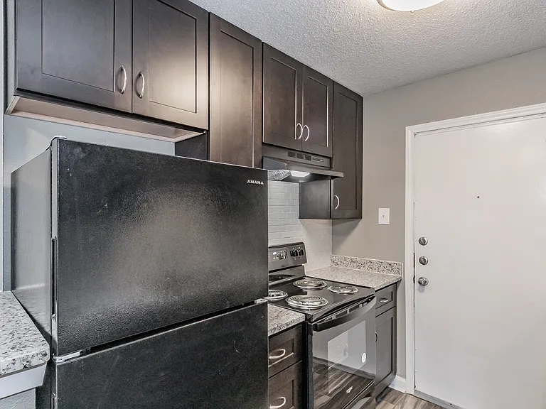 Enjoy cooking in stylish kitchens with dark cabinetry and granite-style counters at Chapel Creek Apartments.