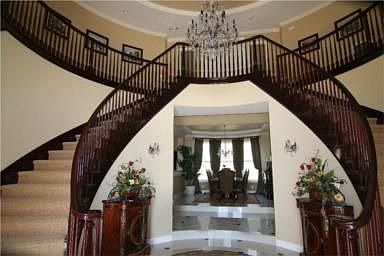 Grand foyer with dual cherry wood staircases 