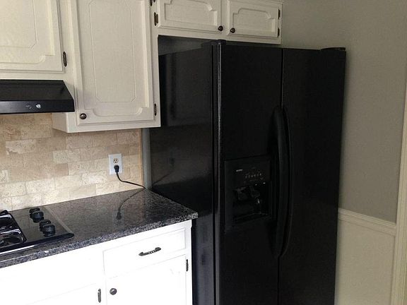 Updated kitchen includes granite counter tops and travertine backsplash.