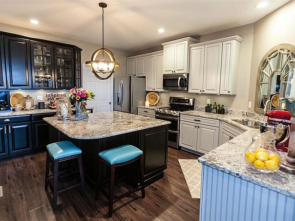 Kitchen recently updated with vinyl plank flooring, 42" inch cabinets, center island with breakfast bar, granite counter top, st