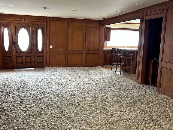 Living room with sneak view to kitchen and small bar area.