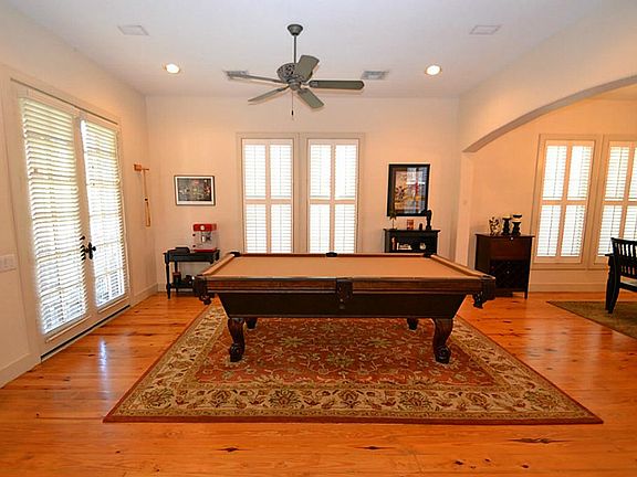 Living room enhanced by Heart of Pine floors, recessed lighting, ceiling fan, plantation shutters and French doors to the front porch.