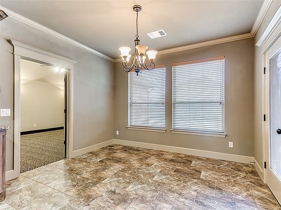 Kitchen eating area with beautiful tile!  An optional game room or second living room to the left and patio door exit on the right.
