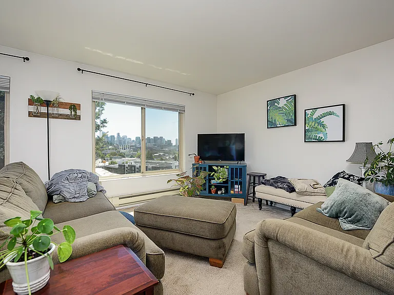 Living room and dining area with south and west view of Downtown Seattle, Space Needle, Lake Union, and east facing for balcony for morning sun into living area