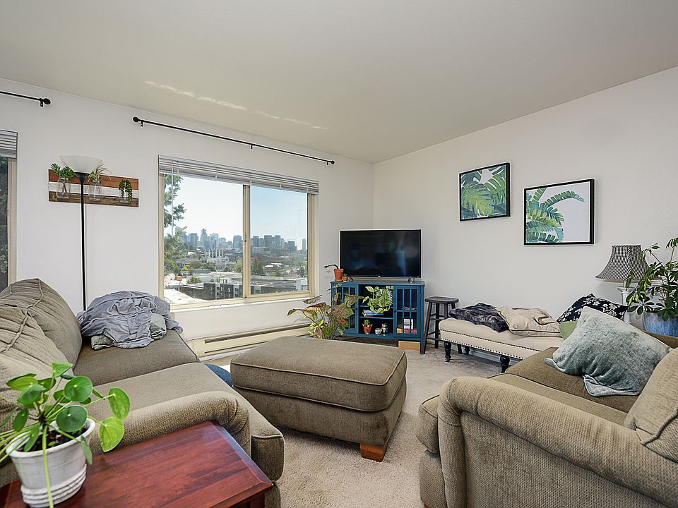 Living room and dining area with south and west view of Downtown Seattle, Space Needle, Lake Union, and east facing for balcony for morning sun into living area
