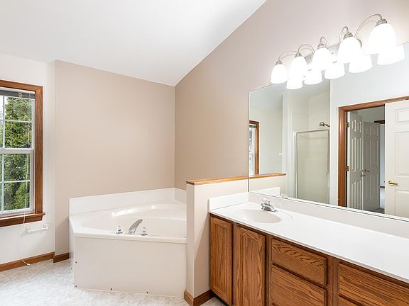 Soaking tub, separate shower reflected in mirror. New flooring