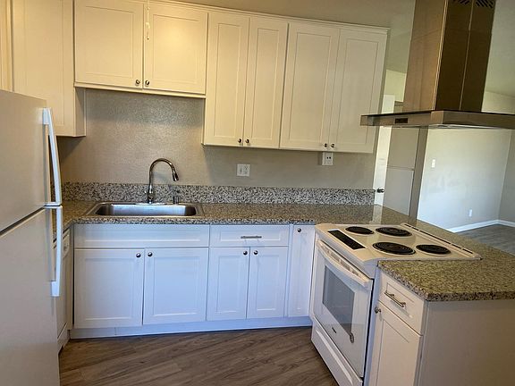 Full sized appliances_ granite stone countertops_ open floor plan to front room_ stainless steel sink_ drop down range hood