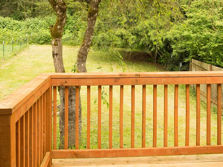 Private deck overlooking a peaceful backyard with mature trees and a quiet natural setting. Great space to relax outdoors.