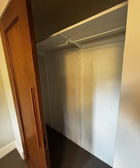 Large closet has a shelf, hanging rack and hooks.