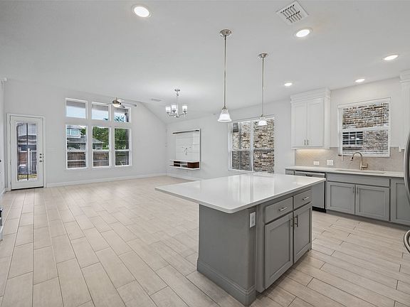 View from kitchen to dining area and into living area. Full view of spacious backyard.