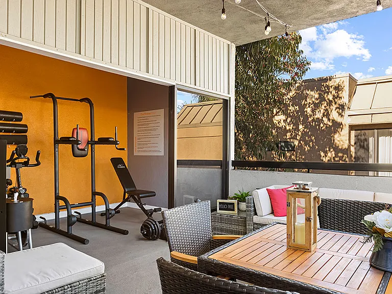On-site fitness center with weight equipment and view of lounge.