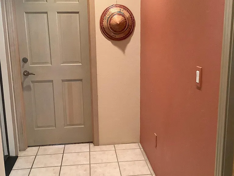 A little alcove leading to bedroom . Bedroom is furnished with memory foam mattress, dresser, etc. Two windows look onto private natural area with trees.