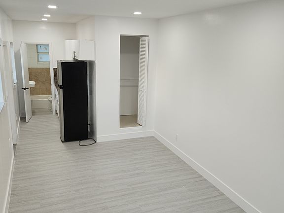 Efficiency living area with closet and kitchenette in background