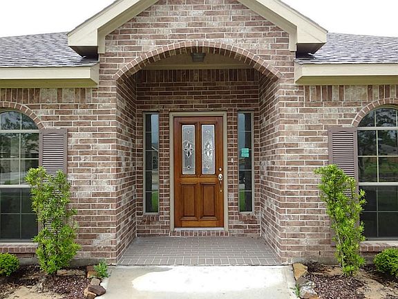 The covered front entry features a wood and leaded glass front door with side lights.