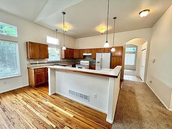 View of dining area, bar, and kitchen from the living room.