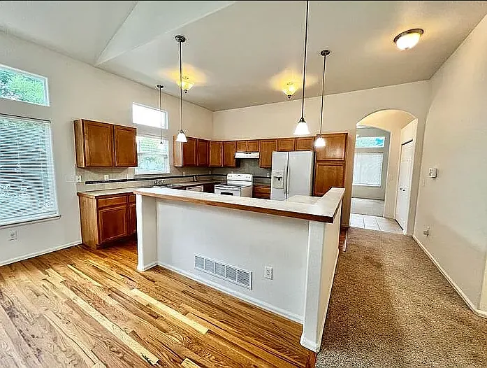 View of dining area, bar, and kitchen from the living room.