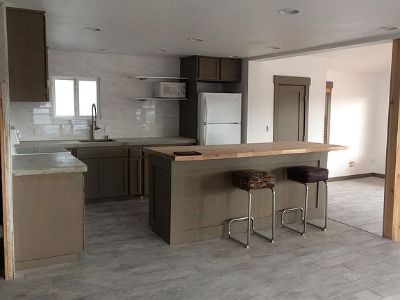 Kitchen has a stove, fridge, and dishwasher. Includes Concrete countertops, butcherblock island and pantry. Large open area that will accommodate dining and living.