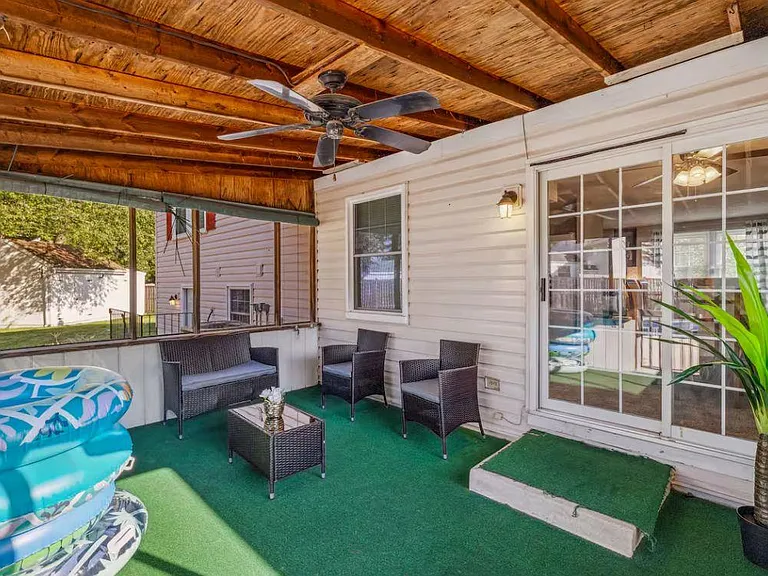 Covered patio with a ceiling fan, outdoor seating set, and sliding glass door access to the home for easy indoor-outdoor livi