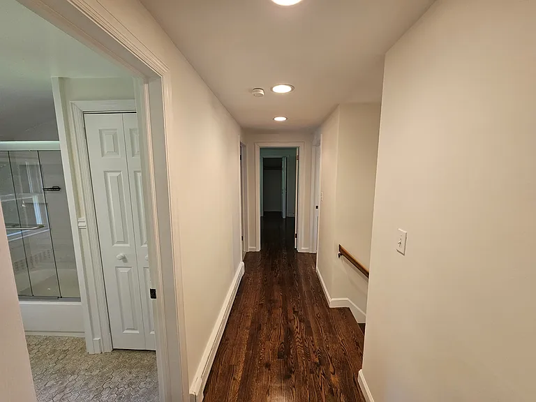 1st Floor Hallway view 1 - with the bathroom on the left, laundry area farther down on the left, Bedroom 4 directly ahead, and Bedroom 3 on the right.