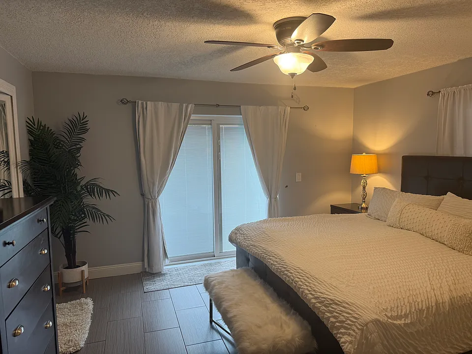 Master Bedroom with sliding glass door (blinds inside) that leads to outdoor deck.