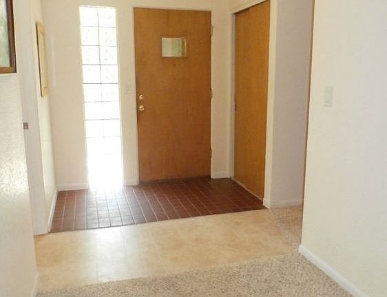 The original details of this foyer are the glass block side light and tile floors.