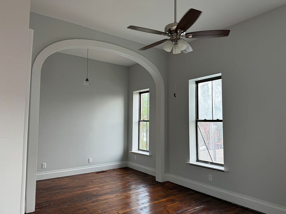 Master bedroom featuring high ceilings, original hardwood floors, and plenty of natural light