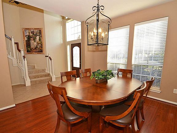 The formal dining room has rich wood laminate floors with one wall of windows. The other wall is perfect for your favorite art work or china cabinet!