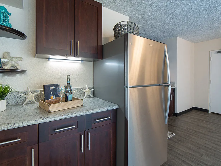 Waikiki Walina Apartments entry way and kitchen area with appliances, cabinets, and counters