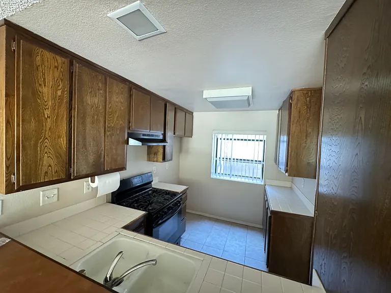 Kitchen view from living room, features stove, dishwasher and plenty of cabinet space. Also a cute bay window for person touches