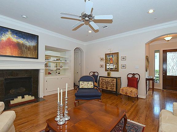 Open living area is quite cozy and offers recessed lighting, custom cabinetry, stately gas log fireplace and ceiling fan.