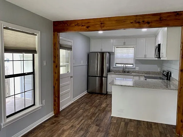 kitchen with side door leading to carport and washer and dryer and back yard.