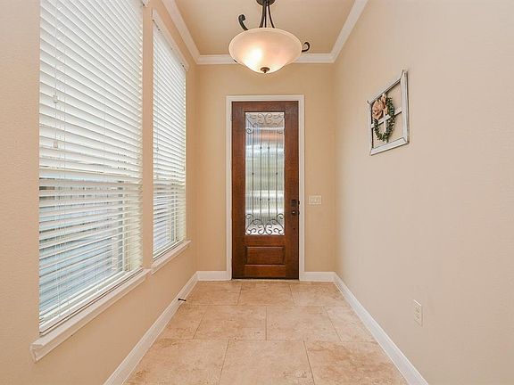 Large formal entry with high ceilings and Travertine floors.