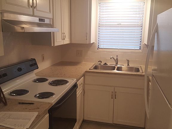 Galley kitchen with new counters, sink, vent hood, refrigerator