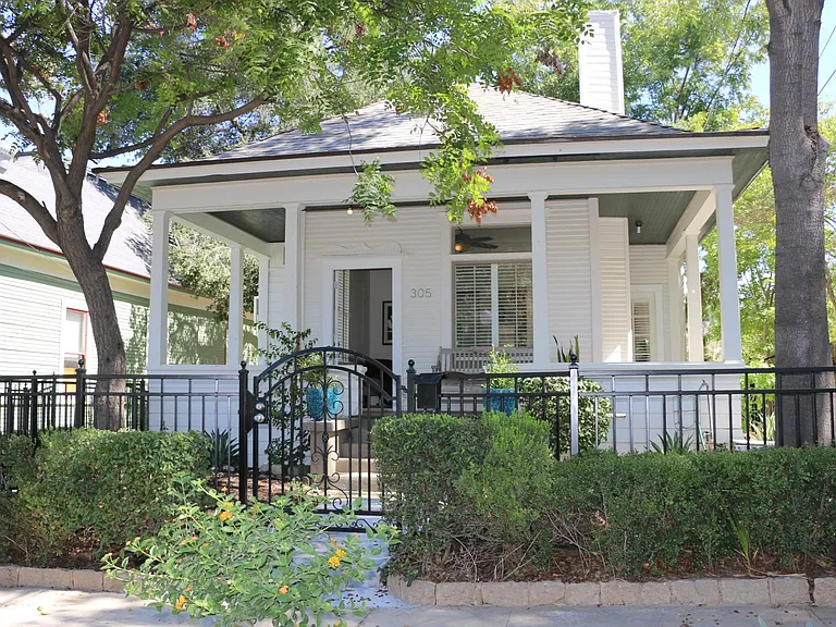 The entire front of the property is gated; and backyard is completely enclosed by a six-foot high cinderblock garden wall. Part of the garden wall is covered in dark green English creeping fig vines.