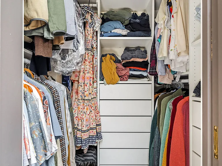 Walk-in closet with 5 hanging racks and two sets of drawers / shelves
