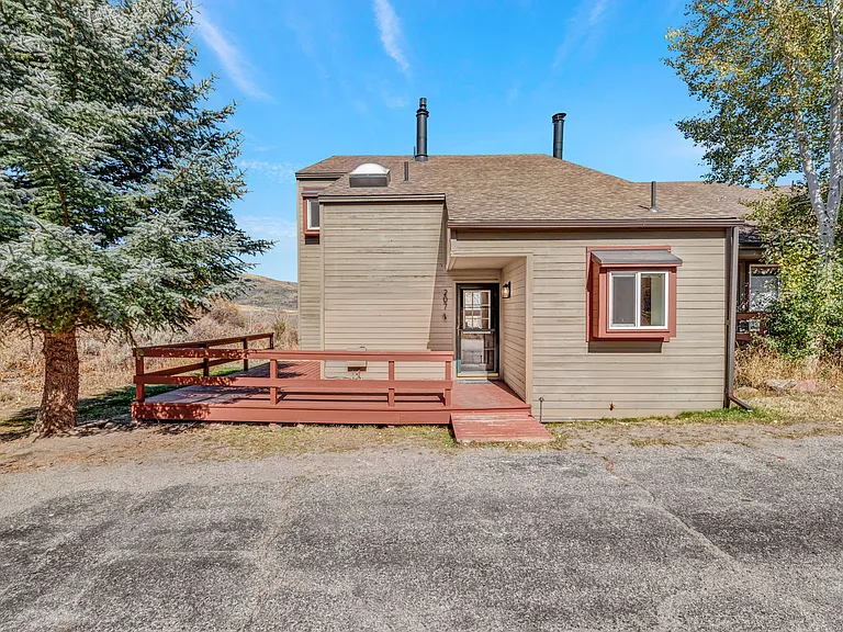 #207 is an end unit, with a wrap around front deck, small back storage shed, and parking area out front