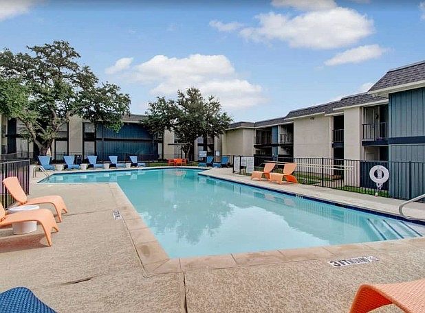 Sparkling swimming pool surrounded by sundeck chairs