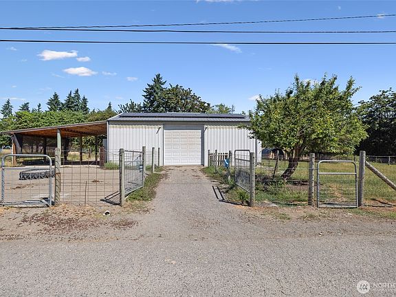 Barn- A car-charger plug is in place for added convenience. The space also features built-in livestock feeders, dedicated hay storage, and a defined pen area with durable concrete flooring. Cross-fencing completes the setup.>
