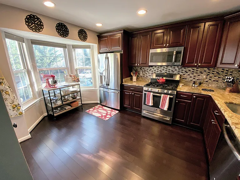 Custom kitchen with cherry cabinets, granite countertops, stainless steel gas appliances, dining room pass through, and ample natural light.
