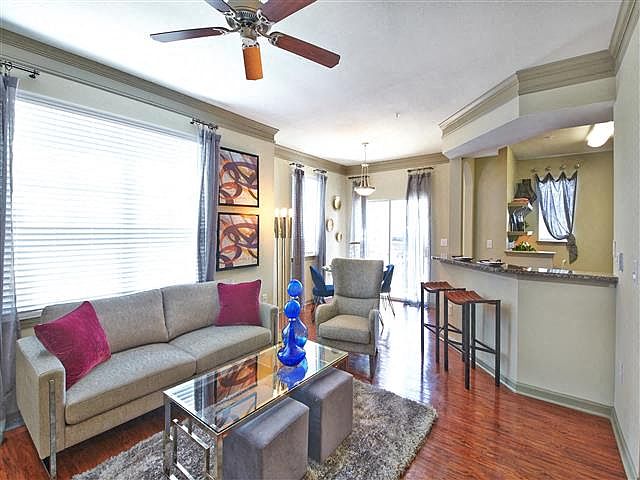 Living room with large window, wood-style flooring and ceiling fan