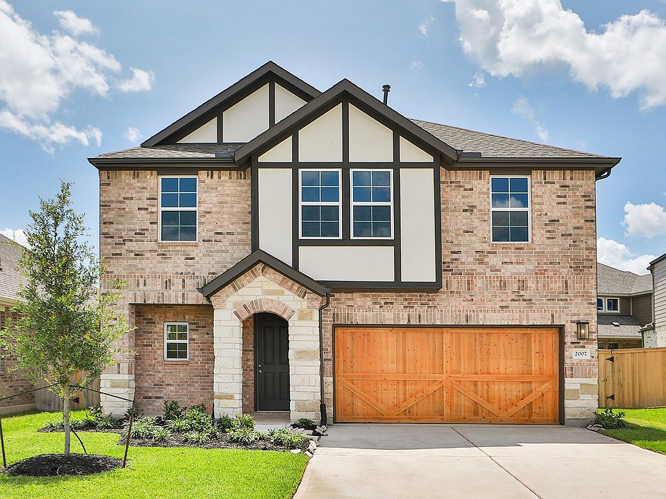 Elegant brick facade with custom wood garage and stone archway at Maui s Park at Eldridge.