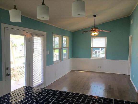 Large living room with vaulted ceilings and natural light. Laminate floors.